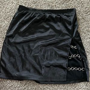 Black mini skirt with stretchy fabric. Cute silver rings at opening